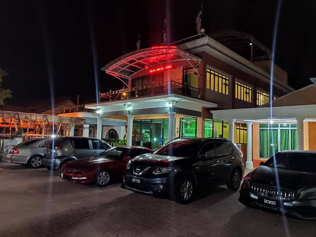 a parking lot with cars parked in front of a building at DARUL SALAM INN HOTEL in Kertih