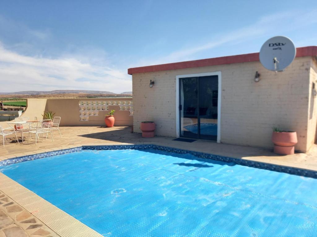 a swimming pool in front of a house at Brandwag Pool Room in Prieska