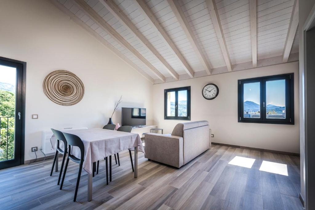 a living room with a table and chairs and a clock at Lugano Suites in Gravesano