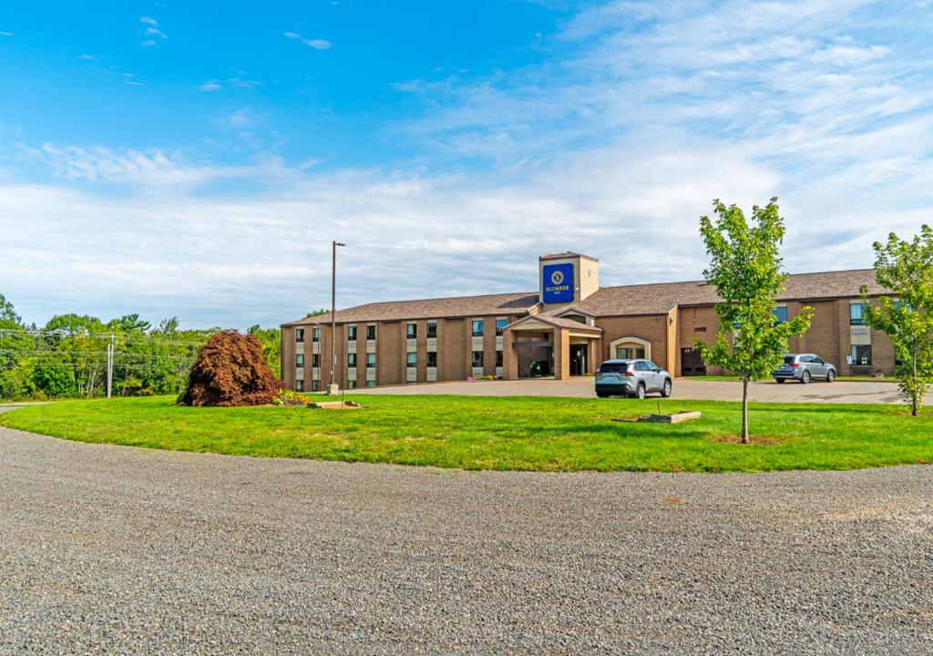 a building with a car parked in front of it at Slumber Inn in New Minas