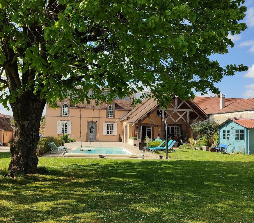 een huis met een zwembad en een boom in de tuin bij Atelier des sens 89 in Évry
