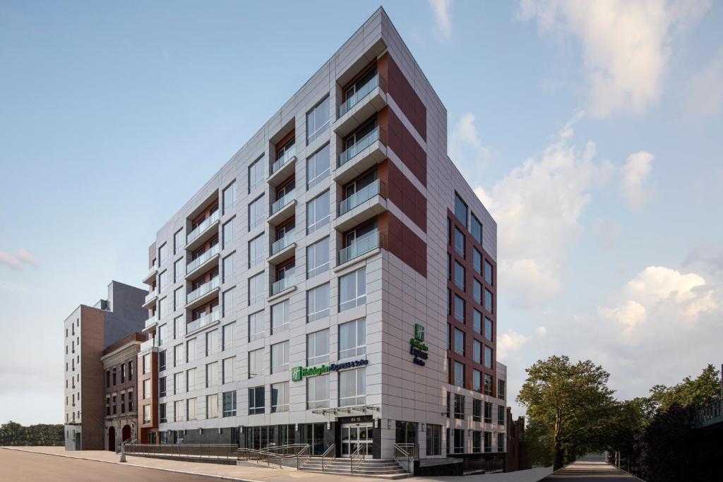 um edifício branco alto na esquina de uma rua em Holiday Inn Express & Suites Woodside LaGuardia Airport em Queens