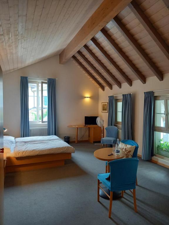a bedroom with a bed and a table and chairs at Auberge d'Etoy in Rolle