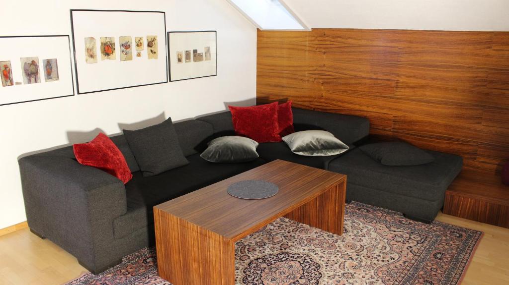 un soggiorno con divano nero e tavolo di Appartement Maria a Egg