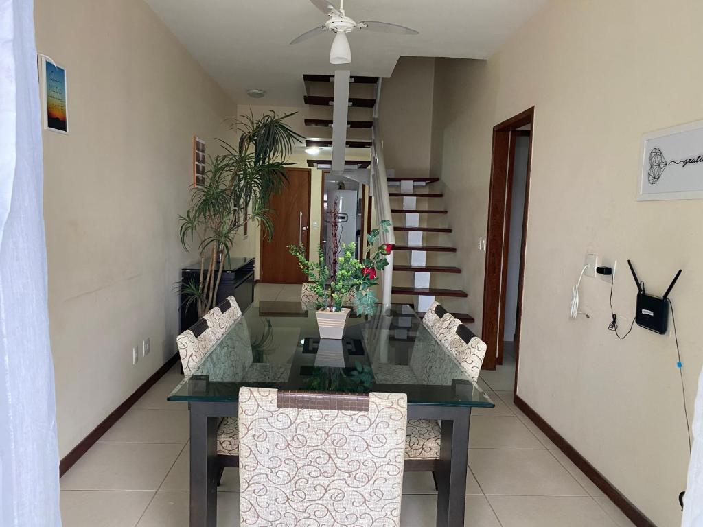 a dining room table with chairs and a ceiling fan at Cobertura Duplex Algodoal in Cabo Frio
