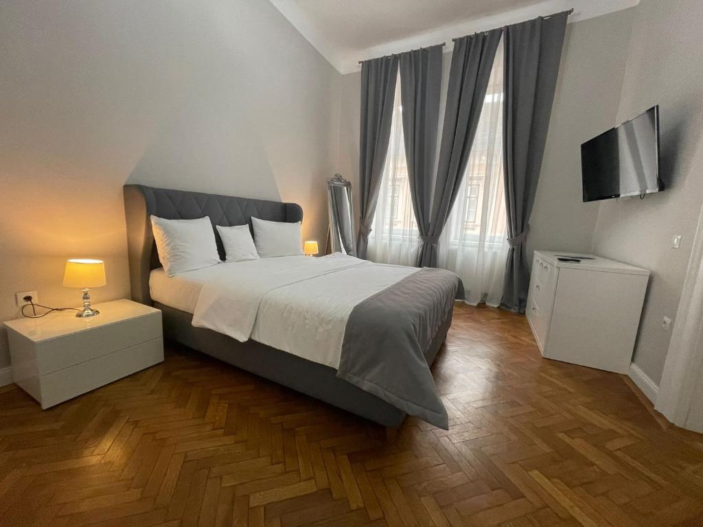 a bedroom with a large bed and two windows at 1501 Wergass 18 in Sibiu
