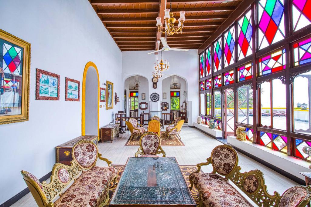 a room with a table and chairs and stained glass windows at Tembo House Hotel in Zanzibar City