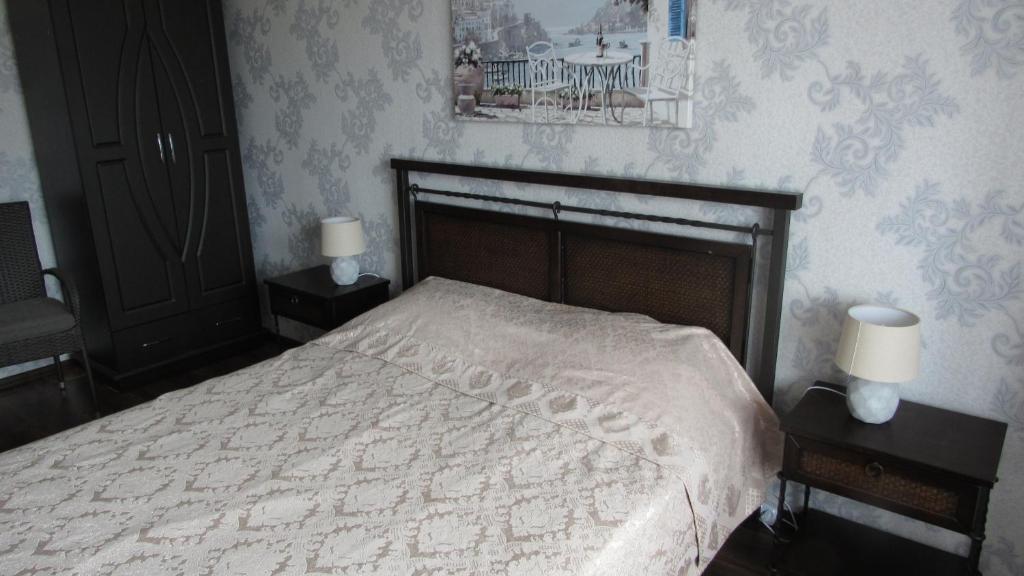 um quarto com uma cama e duas mesas de cabeceira com candeeiros em Аппартаменты в Центре em Poltava