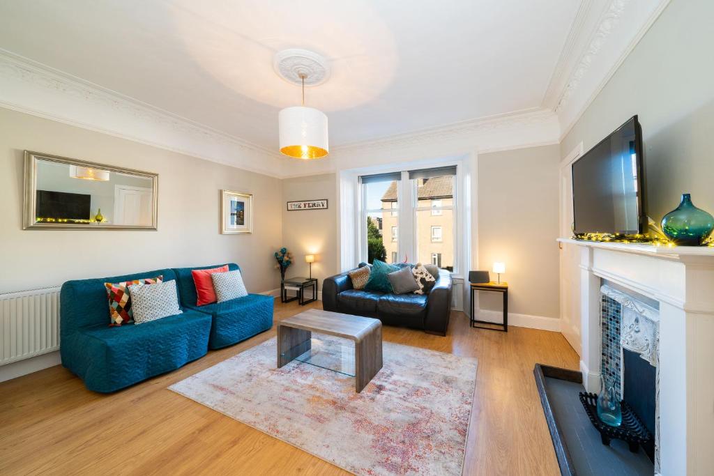 ein Wohnzimmer mit einem blauen Sofa und einem Kamin in der Unterkunft Manor Place in Broughty Ferry
