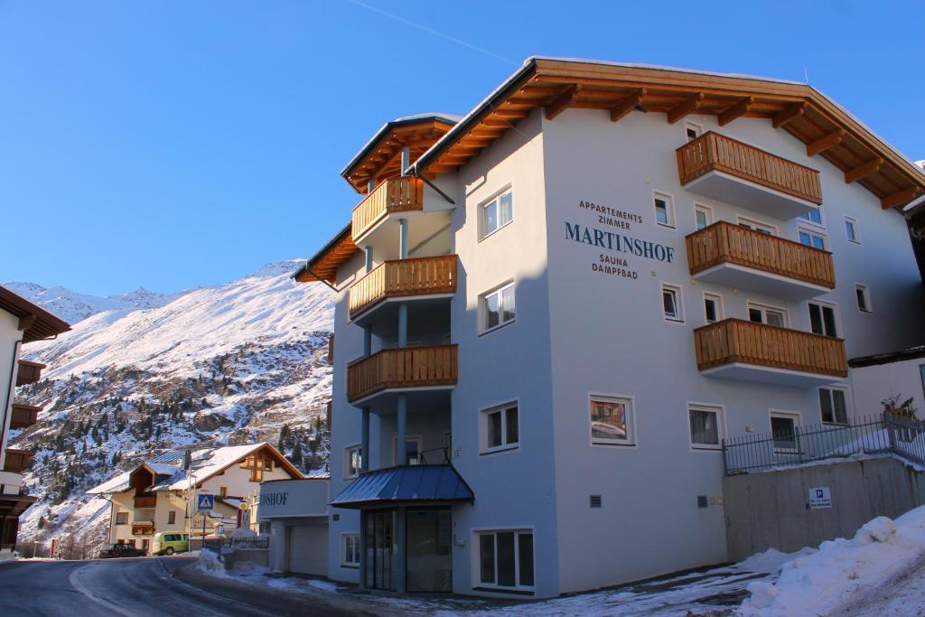 a building in the snow with a mountain in the background at Martinshof in Obergurgl