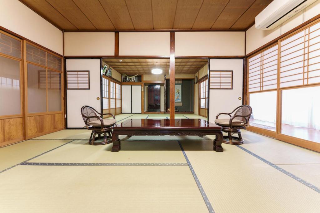 um quarto com uma mesa e cadeiras em Bunzaemon em Itoigawa