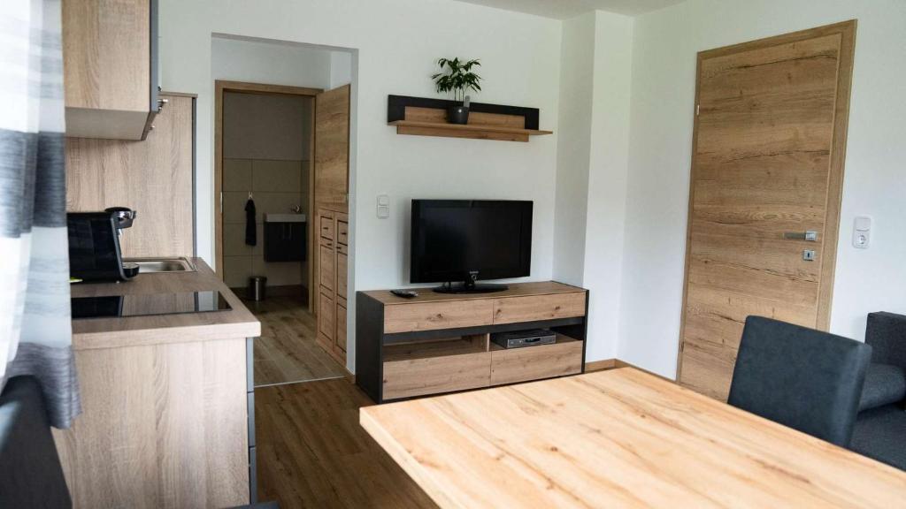 una sala de estar con TV de pantalla plana en un armario de madera en Apartment am Alpakahof Hahn, en Grafenschlag