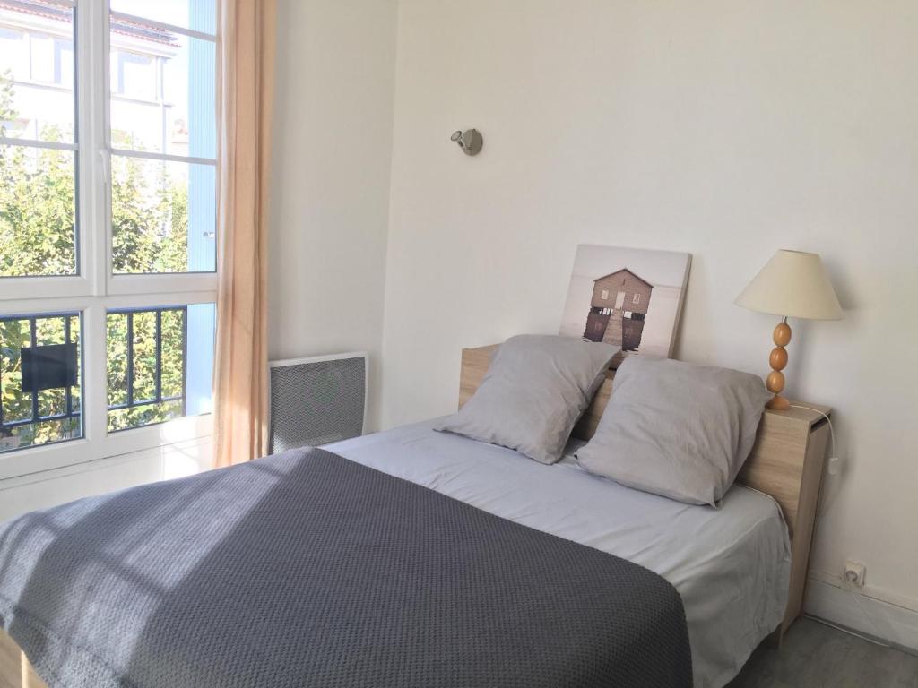um quarto com uma cama e uma janela em Spacieux 2 pièces dans l'hyper-centre em Royan