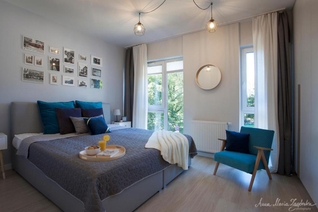a bedroom with a bed and a table and a chair at Olszowa 14 by The River Apartment in Warsaw
