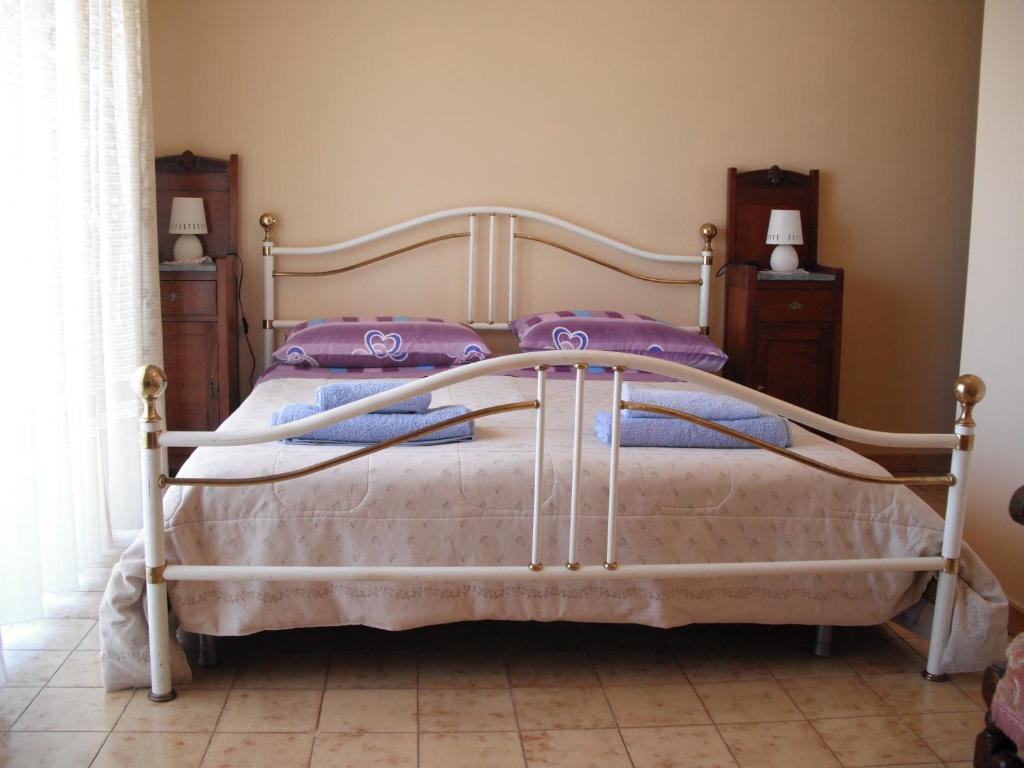 a bedroom with a white bed with purple pillows at Casa Vacanze da Sina in Linguaglossa