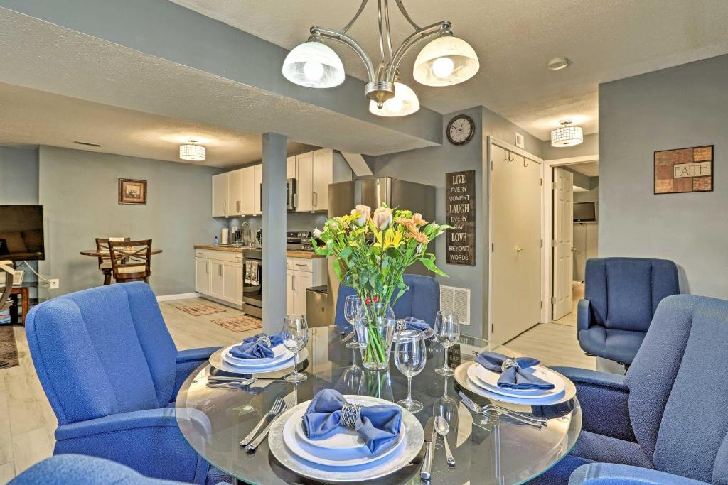 a dining room with blue chairs and a glass table at Lower-Level Woodbridge Apt with Patio - 32 Mi to DC! in Woodbridge