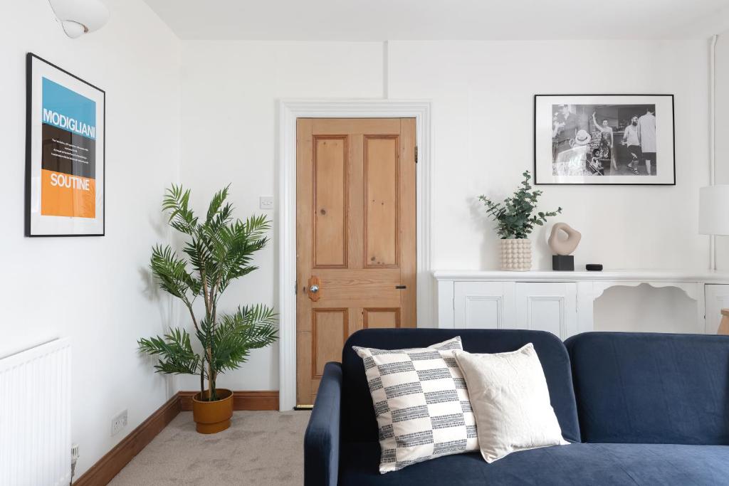 a living room with a blue couch and a plant at Relax in Stunning Apartment In Leafy Victorian Area in Cardiff
