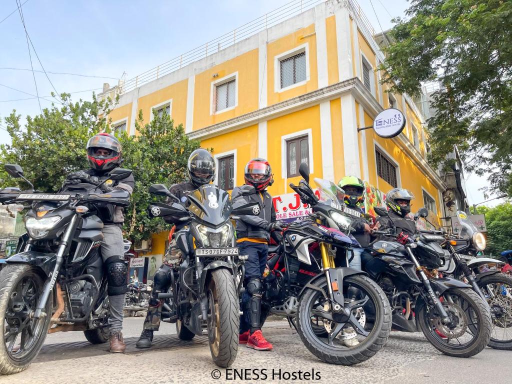 un grupo de personas en motocicletas estacionado frente a un edificio en Eness Hostels Pondicherry en Pondicherry