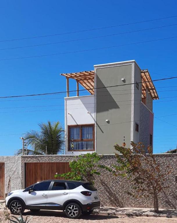 a white car parked in front of a house at Casa Verde Canoa Quebrada in Canoa Quebrada