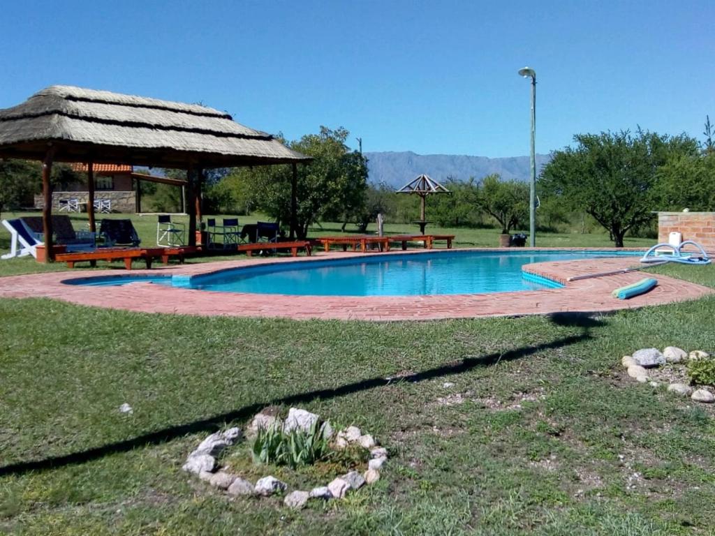 a swimming pool in a yard with a gazebo at Alto Valle Cabañas de Montaña in Mina Clavero