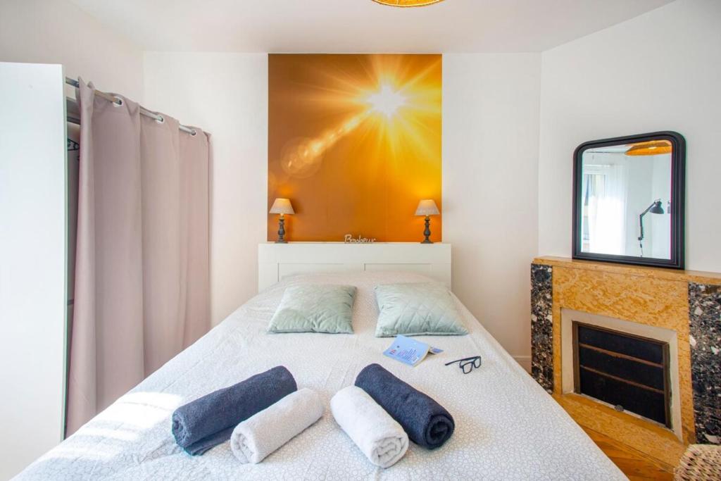 um quarto com uma cama com duas almofadas e uma lareira em L'Aparté HYPER CENTRE LUMINEUX em Lorient