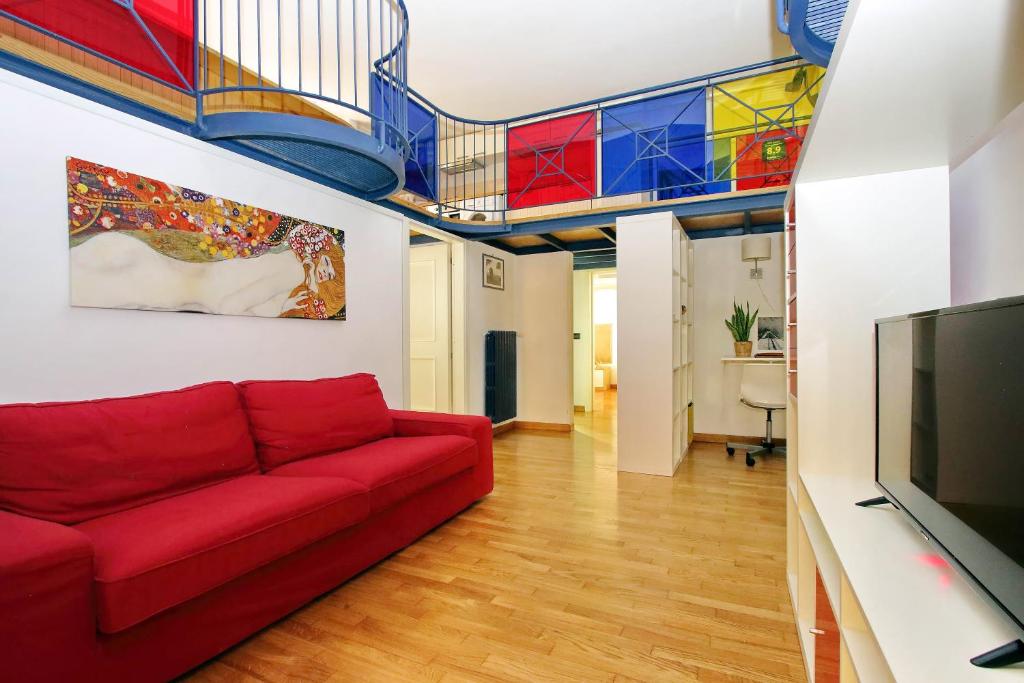 ローマにあるVatican Holiday Homeの赤いソファとステンドグラスの天井が備わるリビングルーム