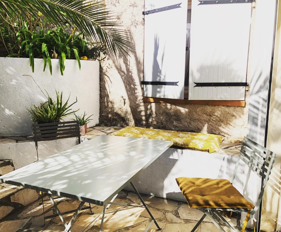 a table and chairs on a patio with plants at L’appartement - Jardin Secret in Marseille