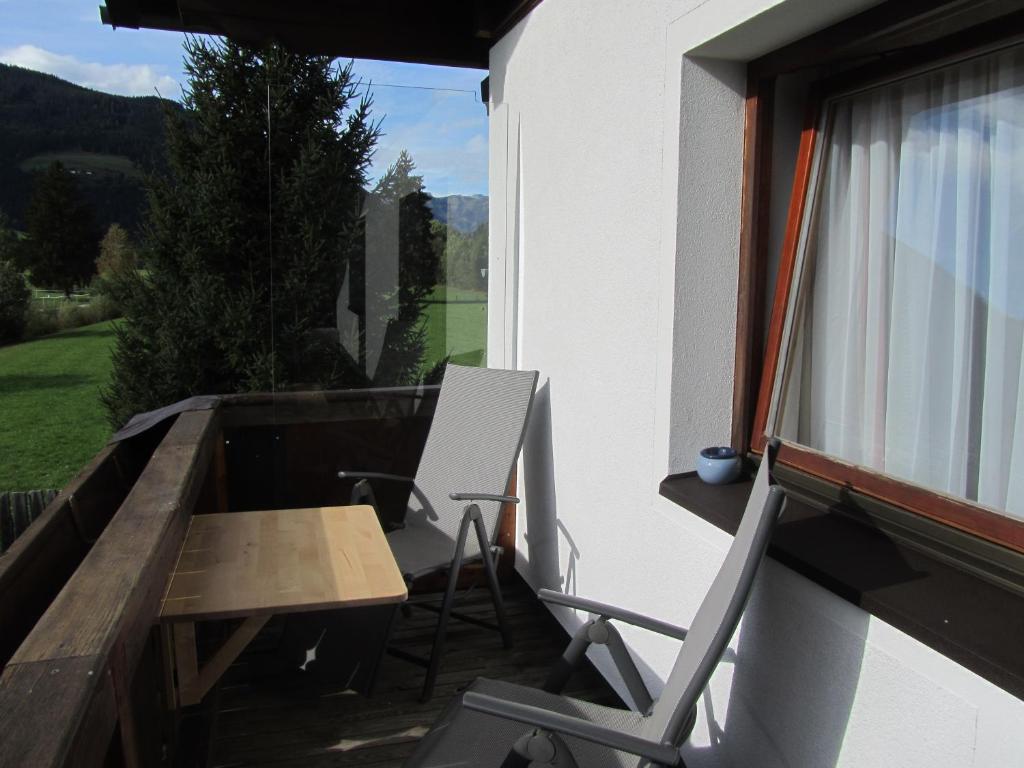 a balcony with a desk and a chair and a table at Ferienwohnung Familie Wieser in Altenmarkt im Pongau