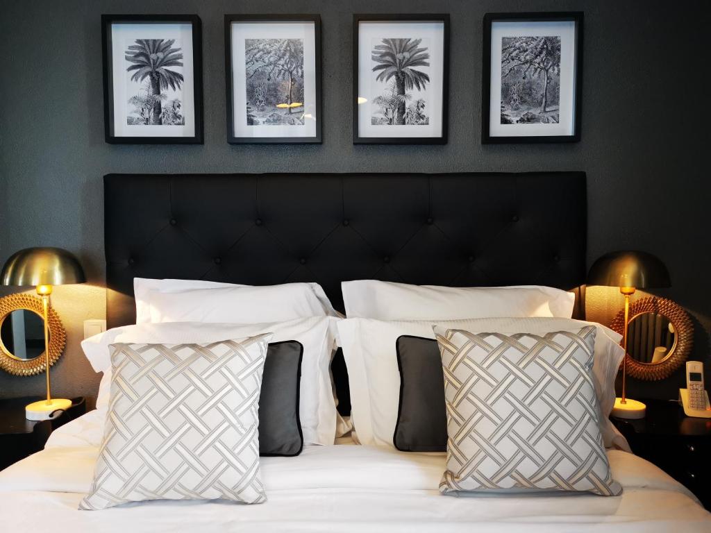 a bed with two pillows and a picture on the wall at Hôtel Le Boeuf Couronné Chartres - Logis Hotels in Chartres