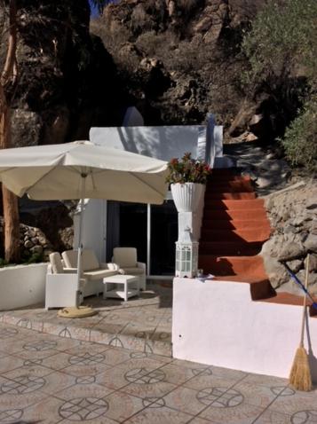 a patio with an umbrella and chairs and a staircase at Urlaub im kleinen Bergparadies in Las Casillas