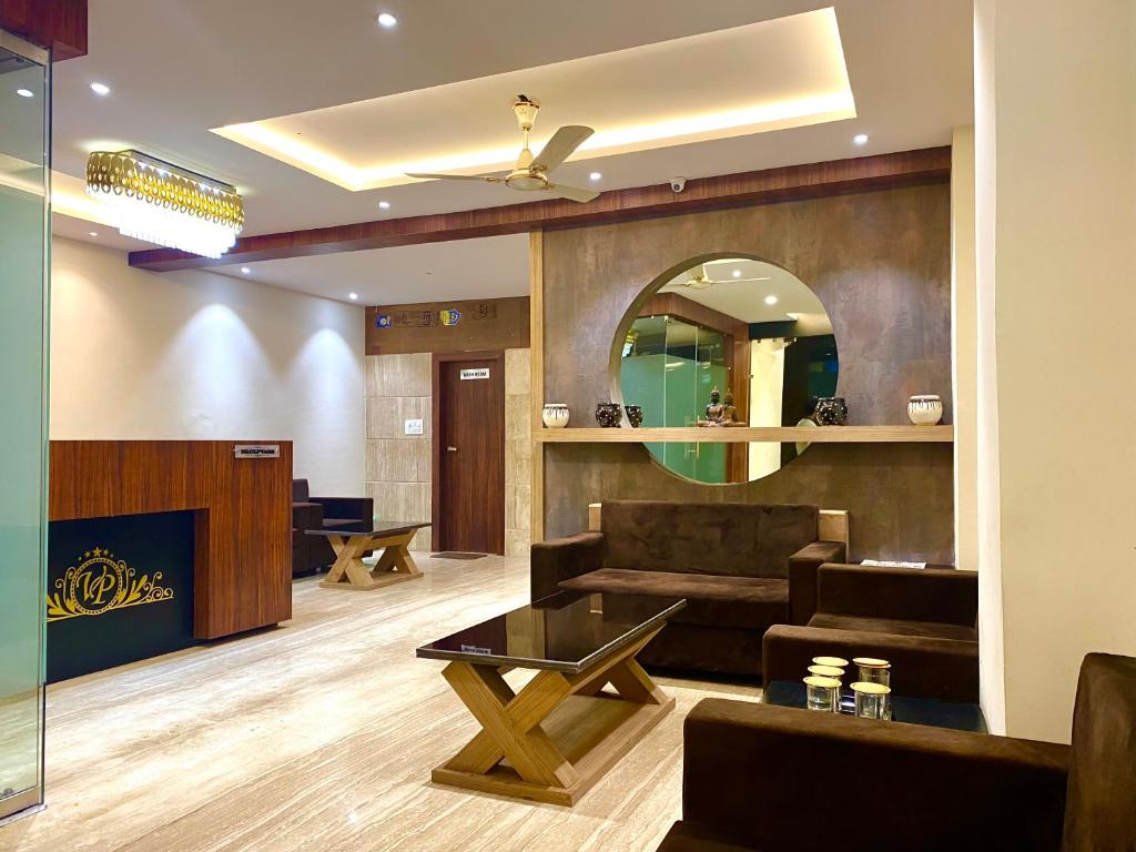 - un salon avec un canapé et une table dans l'établissement Hotel Vrindavan Palace, à Indore