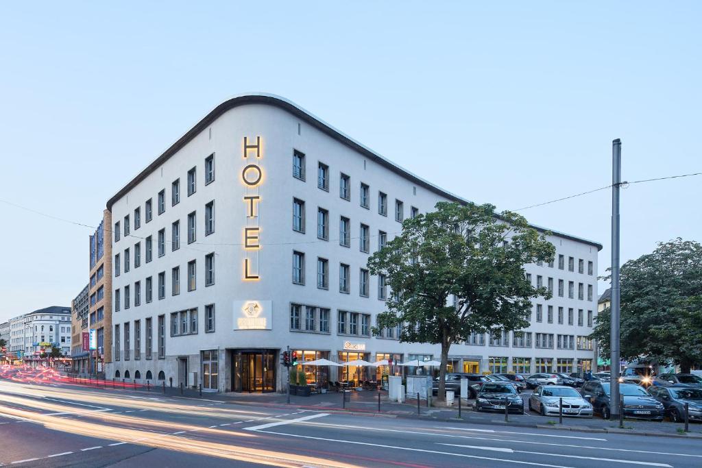 a white building with a sign on the side of it at Postboutique Hotel Wuppertal in Wuppertal