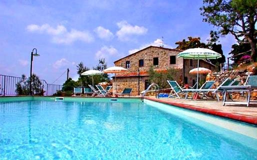 una grande piscina con sedie e ombrelloni di Podere Palazzolo (ADULTS ONLY) a Castellina in Chianti