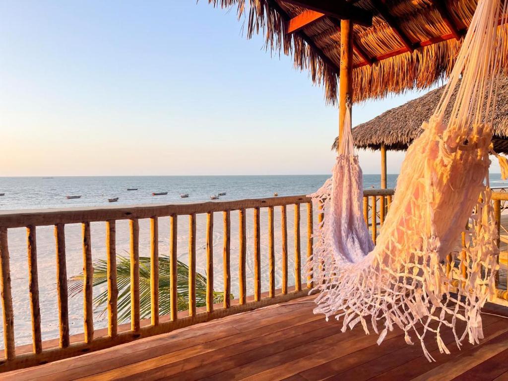 een hangmat op een terras met uitzicht op de oceaan bij Vila Beijú BARRINHA - Frente Mar! in Barrinha