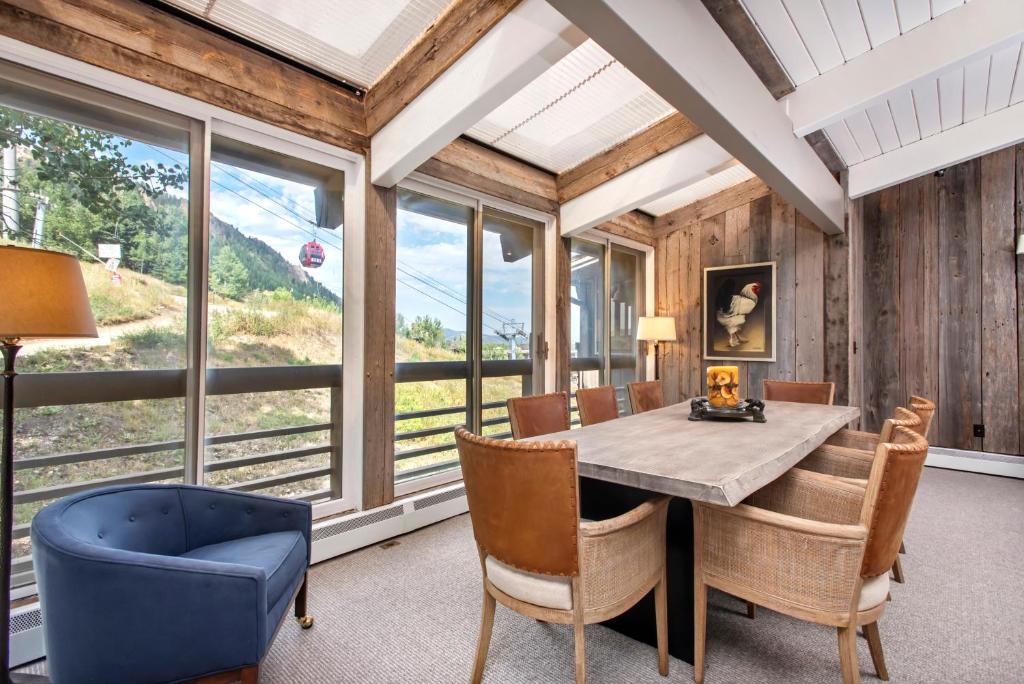 a dining room with a table and chairs and windows at Standard 3 Bedroom - Aspen Alps #803 in Aspen