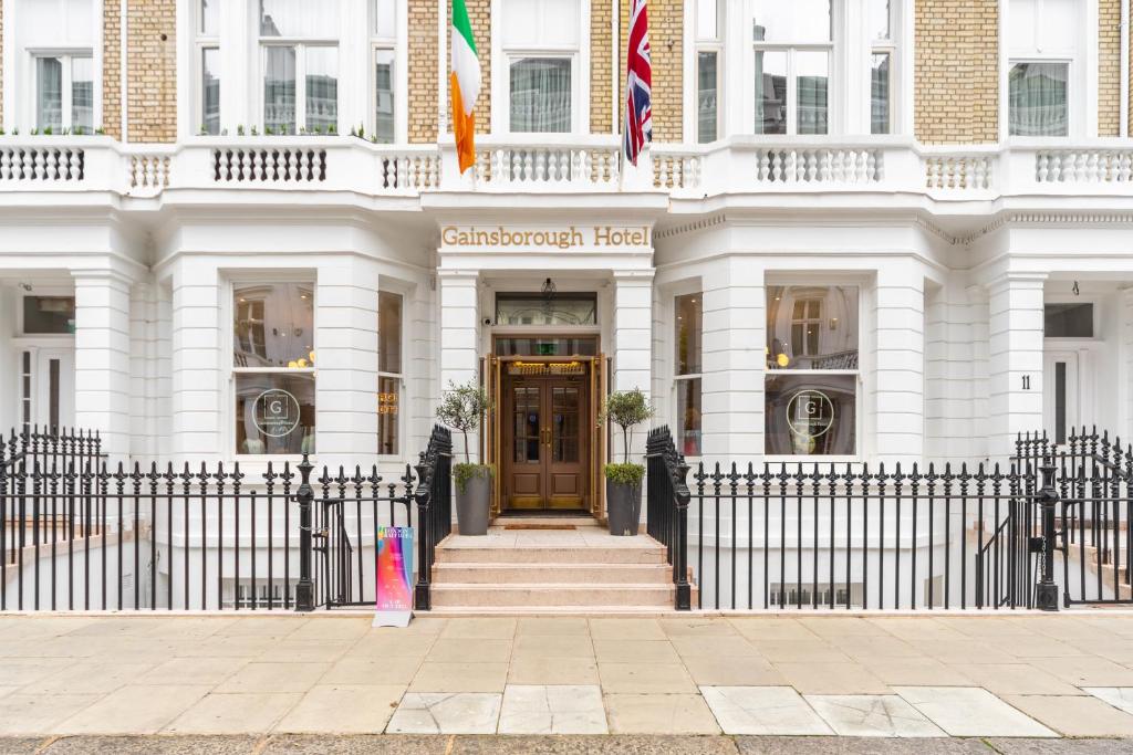 Ein weißes Gebäude mit einem Zaun davor. in der Unterkunft Gainsborough Hotel in London