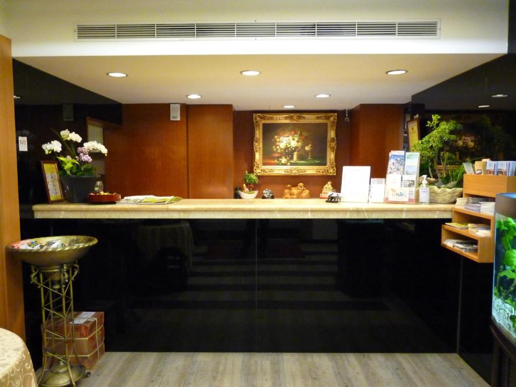 台北的住宿－東姿商務旅館，商店里长长的柜台,墙上挂着照片