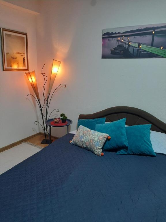 a bedroom with a blue bed with blue pillows at Apartman Maja in Bijeljina