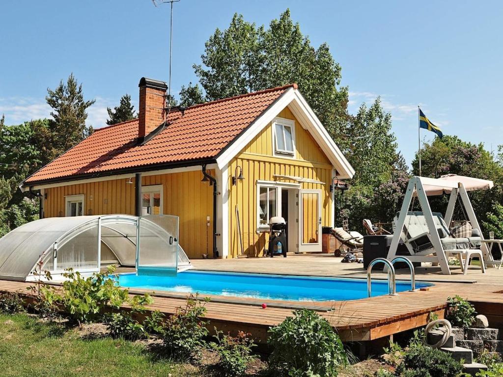 a house with a swimming pool in front of it at Two-Bedroom Holiday home in Blidö 1 in Finnholmen