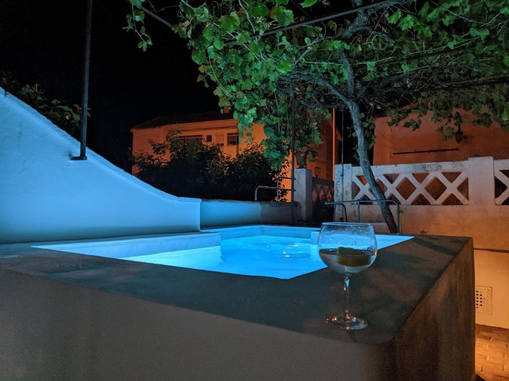 um copo de vinho sentado numa mesa ao lado de uma piscina em Casa de Serpa - Turismo Rural em Serpa