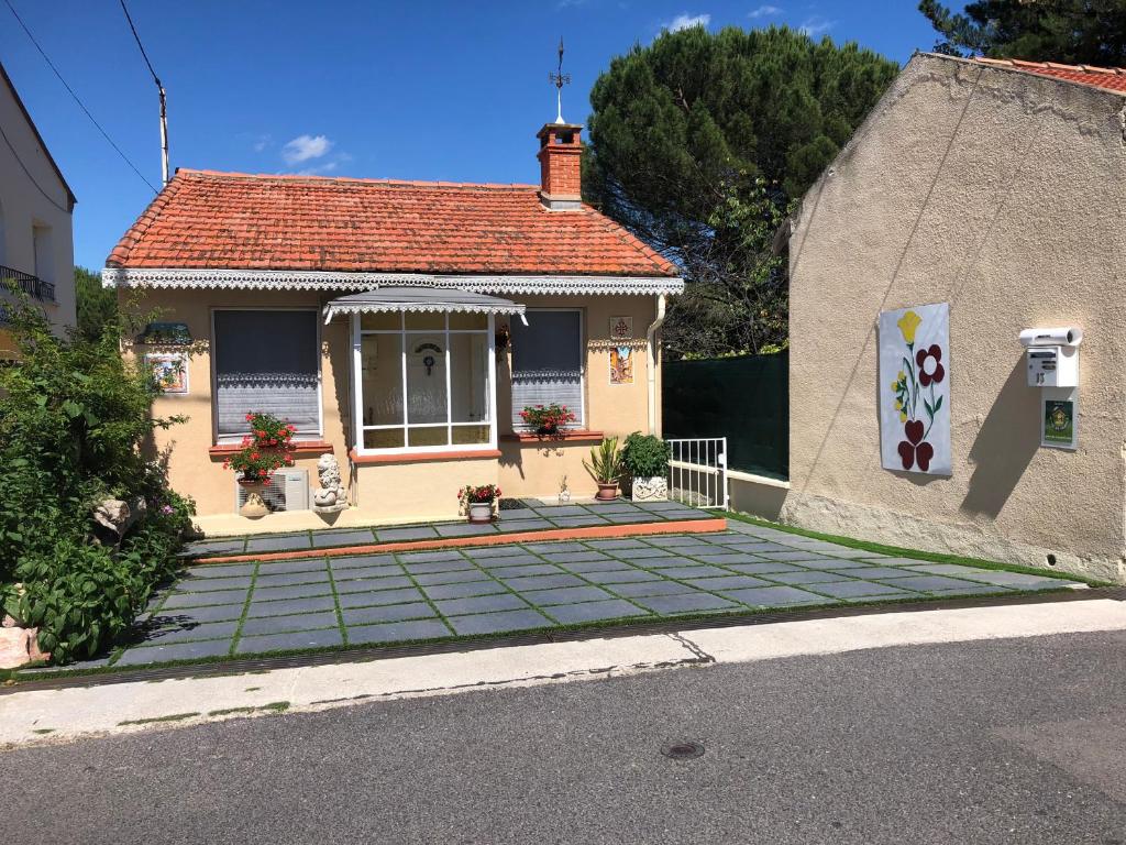 uma pequena casa amarela com telhado de azulejo em Pavillon Clara Flor em Prades