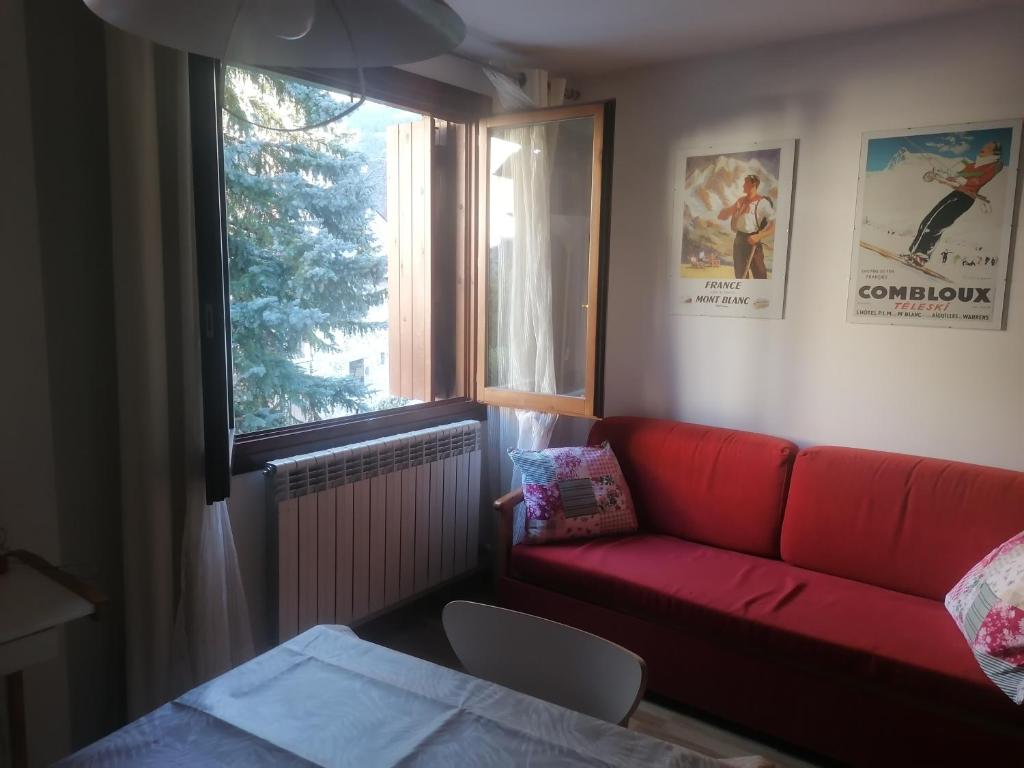 - un salon avec un canapé rouge et une fenêtre dans l'établissement Apartamento Formigal - Sallent de Gállego, à Sallent de Gállego