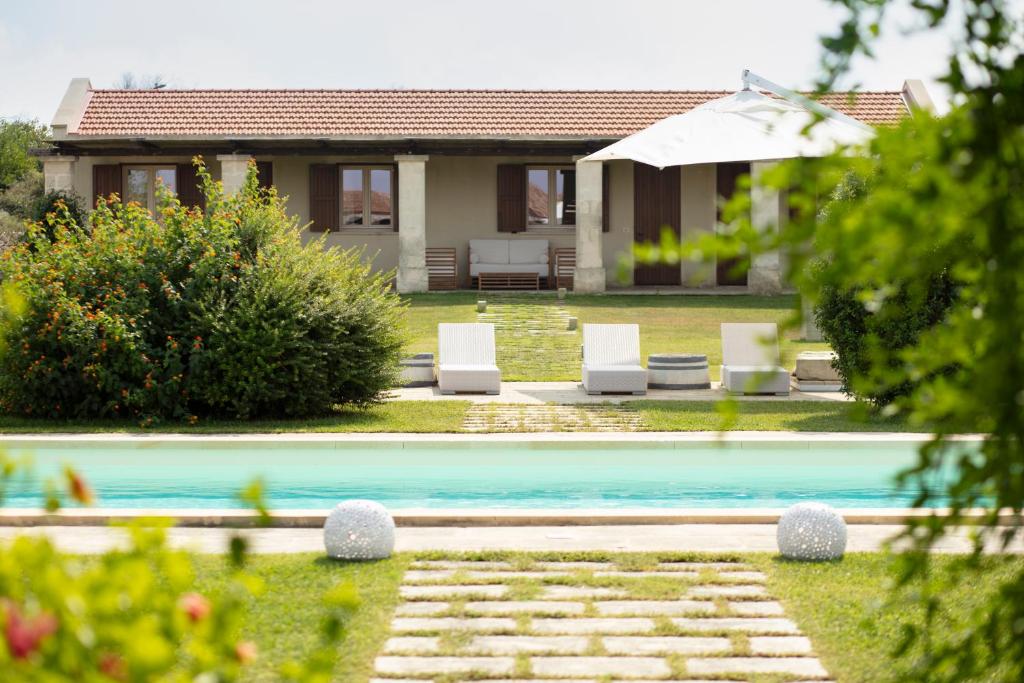 a house with a swimming pool in front of a house at Masseria 30 Mogge in Muro Leccese