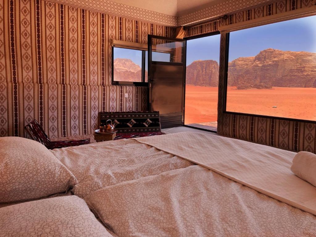 a bedroom with a bed with a view of the desert at Milky Way Bedouin Camp in Wadi Rum