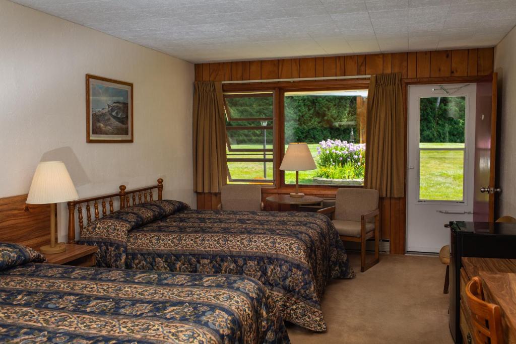 Cette chambre comprend 2 lits et une fenêtre. dans l'établissement Hillside Inn, à Ellison Bay