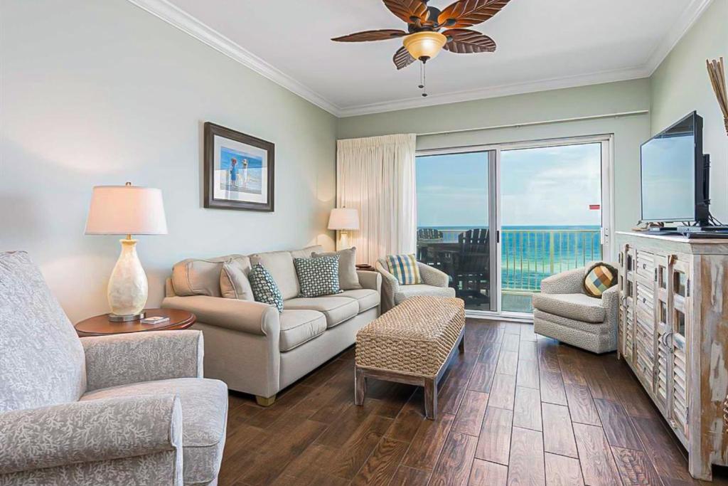 een woonkamer met een bank en stoelen en een tv bij Crystal Shores III in Gulf Shores