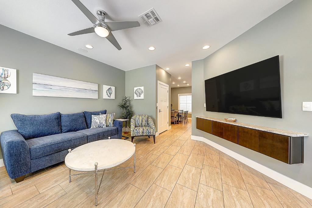 een woonkamer met een blauwe bank en een flatscreen-tv bij Serenity Island in Corpus Christi