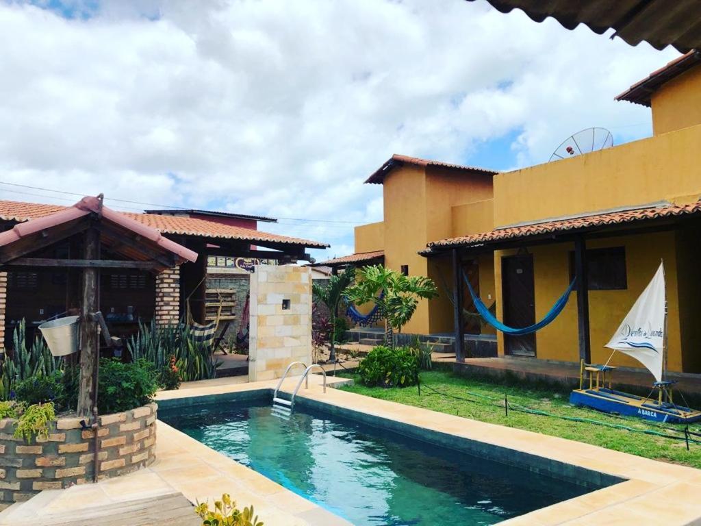 a swimming pool in front of a house at Ventos de Luanda in São Miguel do Gostoso