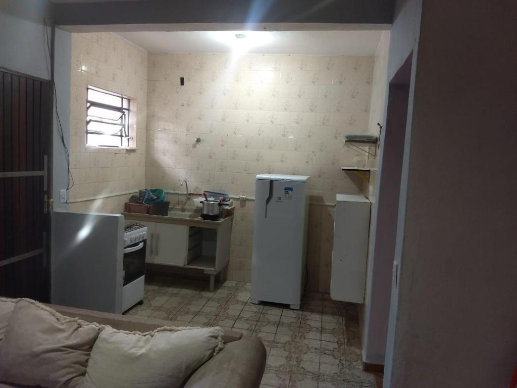 eine kleine Küche mit einem Kühlschrank und einem Tisch in der Unterkunft Ohana Casa 2 Boraceia in Bertioga