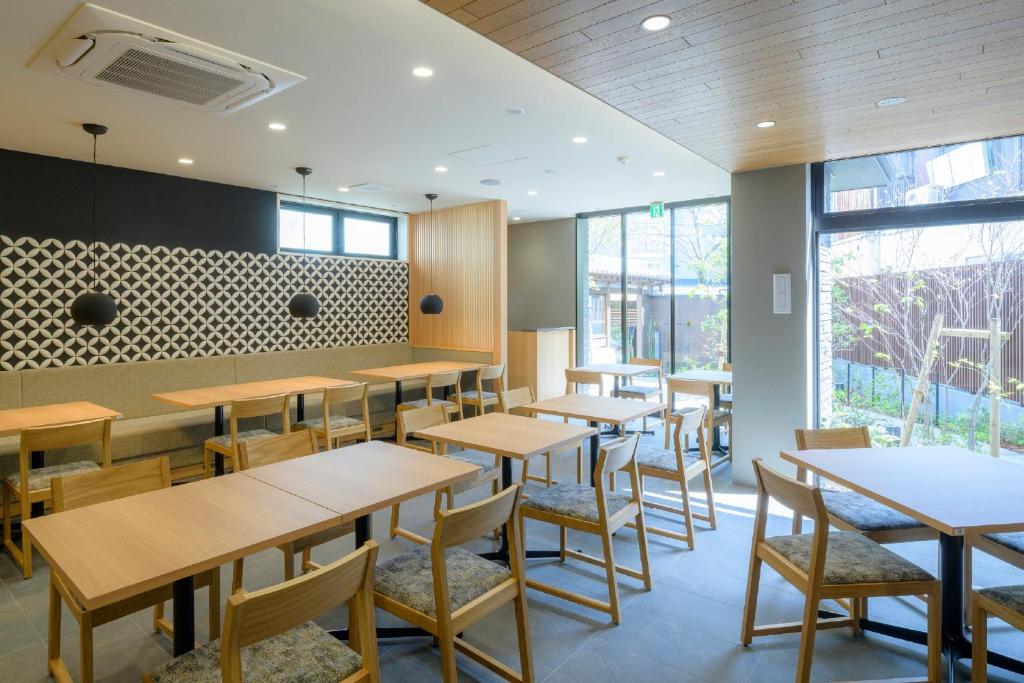 a restaurant with wooden tables and chairs and windows at Tosei Hotel Cocone Kamakura in Kamakura